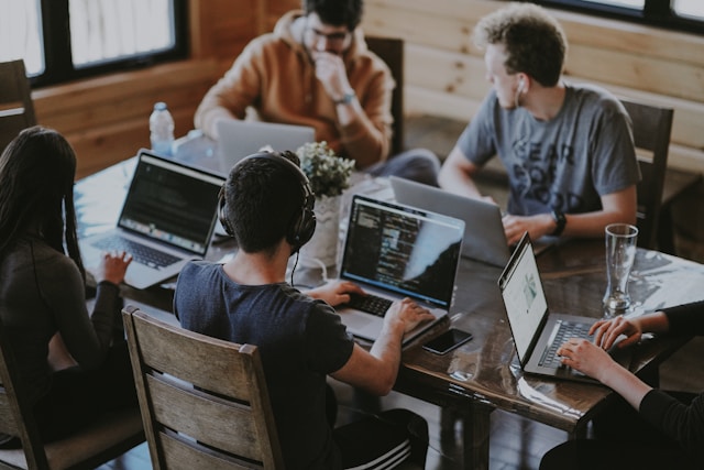 A group of diverse professionals collaborating on a tech project